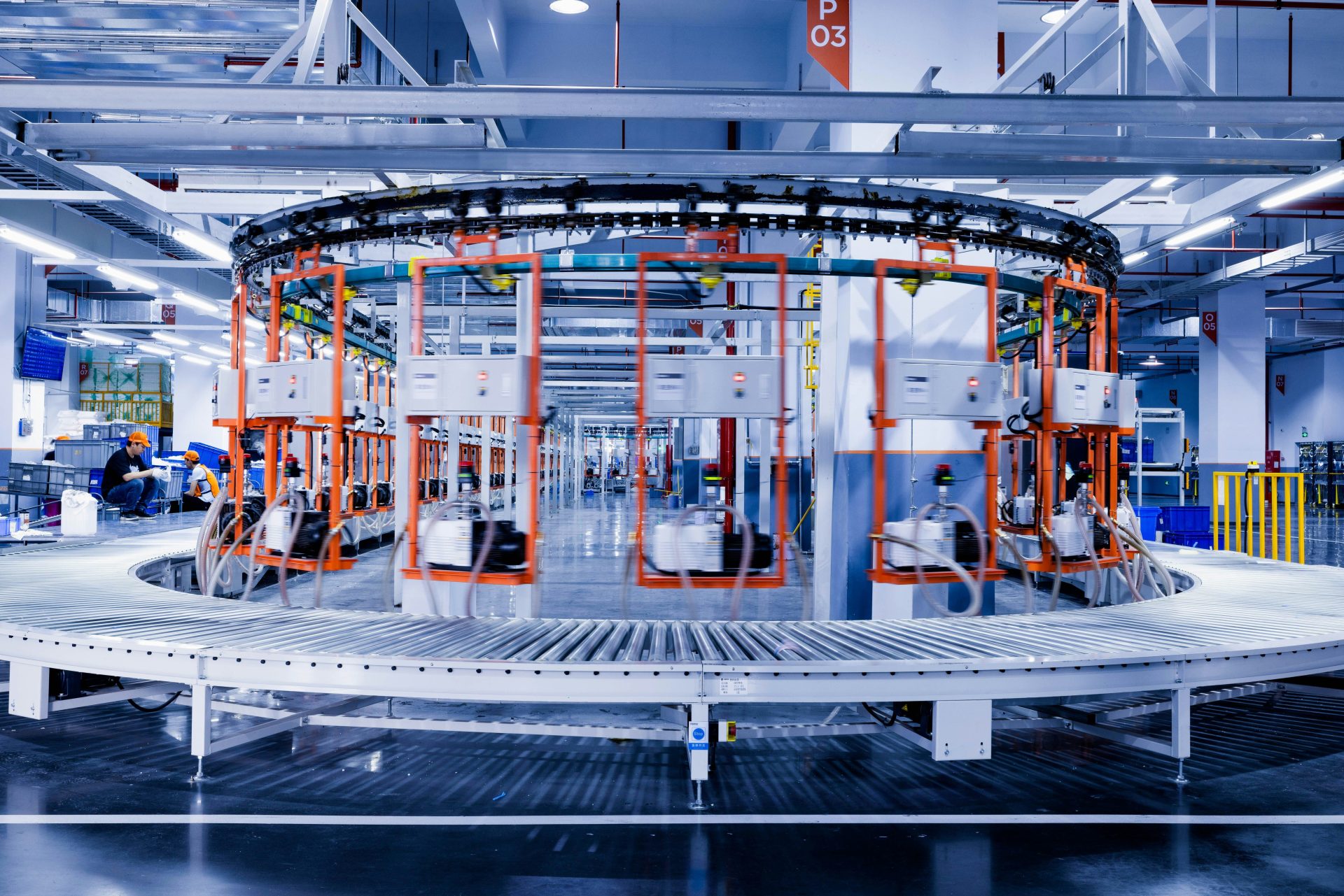 eine große Maschine in einer Fabrik, an der Menschen arbeiten