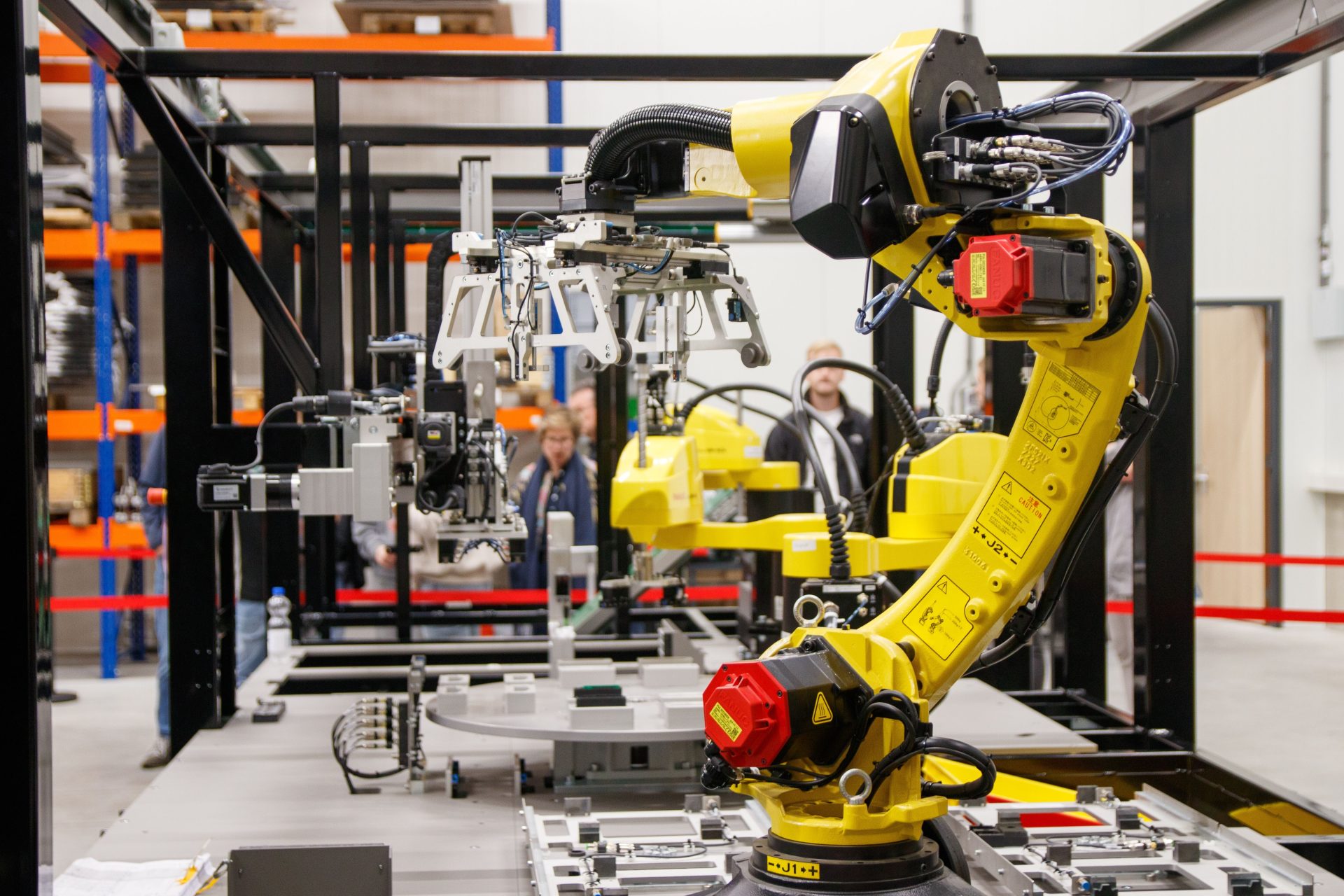 Nahaufnahme eines gelben Industrieroboterarms im Einsatz in einer modernen Produktionsanlage.